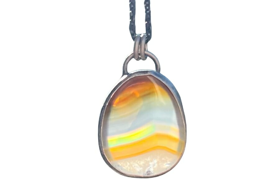 A shiny and shimmering Iris Agate on a silver pendant