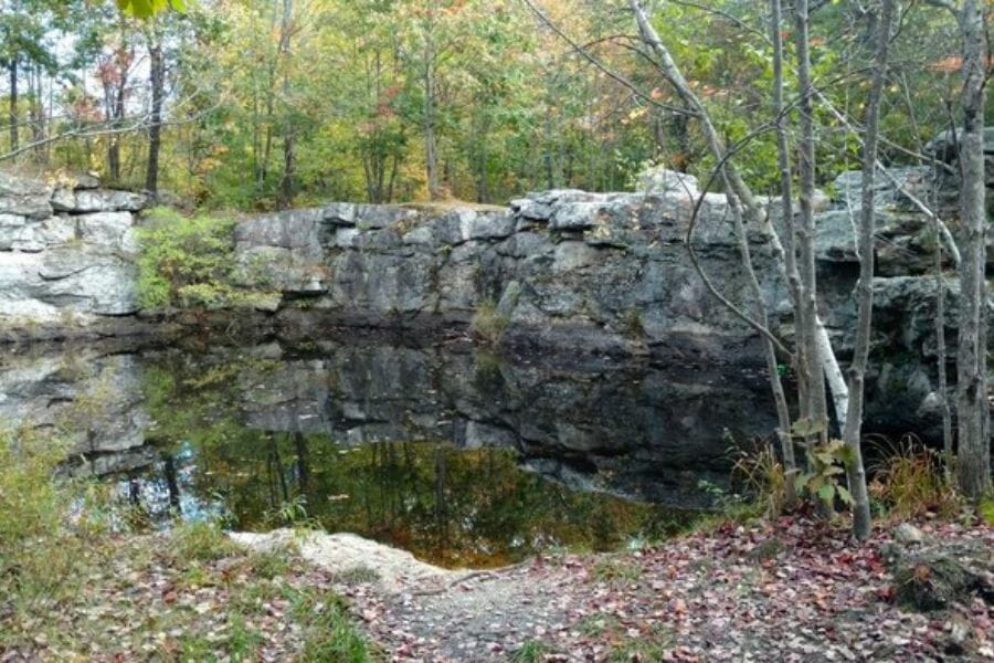 A look at the rock boulders, waters, and surrounding trees at Mount Apatite Quarries