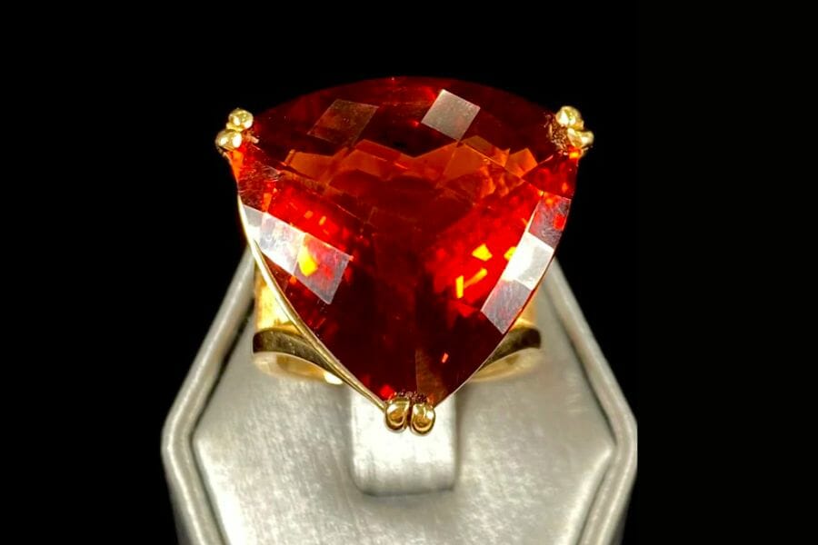 A sparkling piece of red to deep orange Madeira Citrine set as a center stone on a golden ring