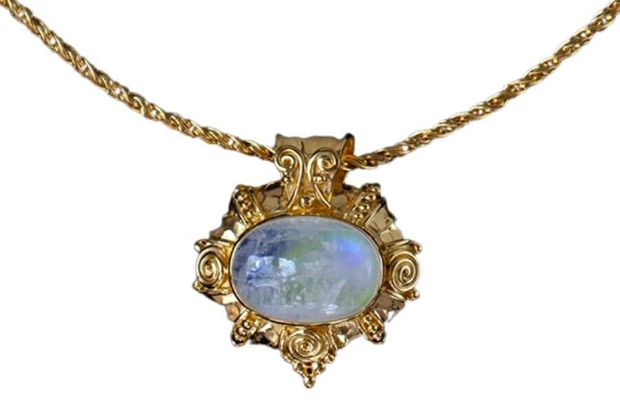 A gold necklace and pendant with a White Moonstone cabochon exhibiting Adularescence
