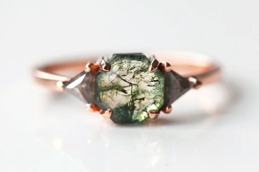 Close up look at the inclusions of a Moss Agate mounted as a center stone on a rose gold ring