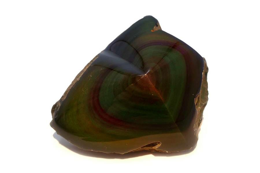A piece of rainbow obsidian with a heart shape in the center in yellow, blue, red, and green
