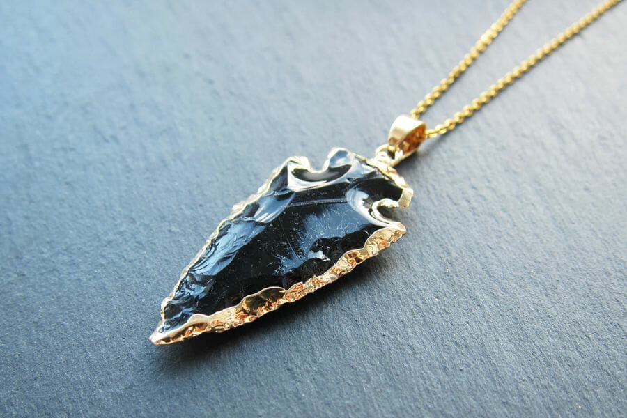 A stylish arrowhead obsidian necklace with gold details