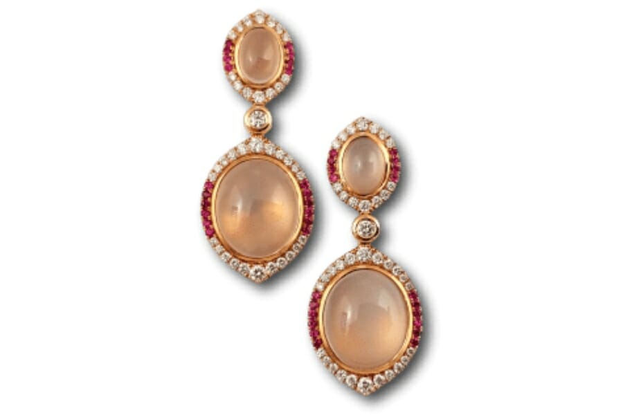 A pair of dangling earrings with two pieces each of peachy pink Moonstones
