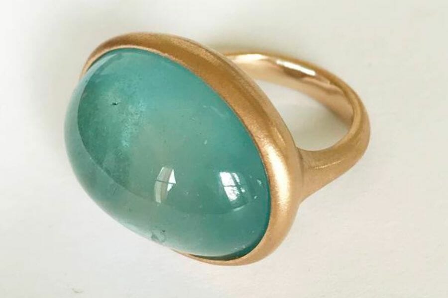 A plain Aquamarine cabochon set as center stone on a golden ring