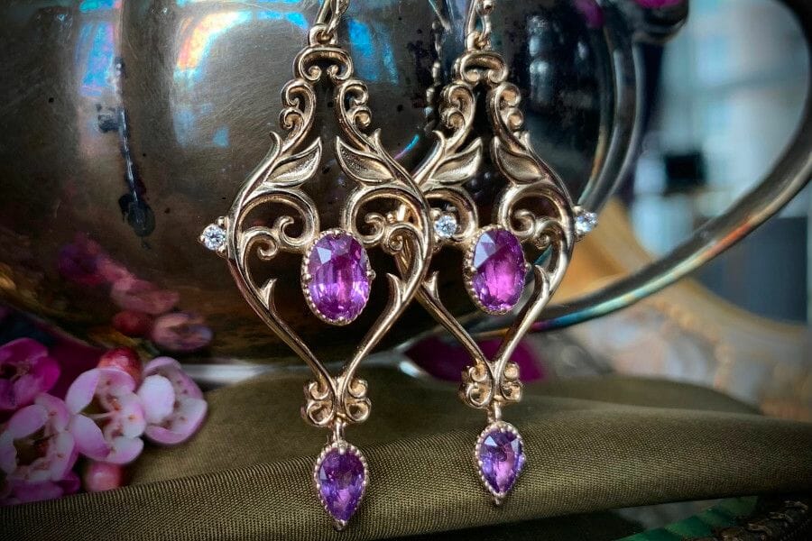 A pair of drop earrings decorated with oval pieces of Purple Sapphires