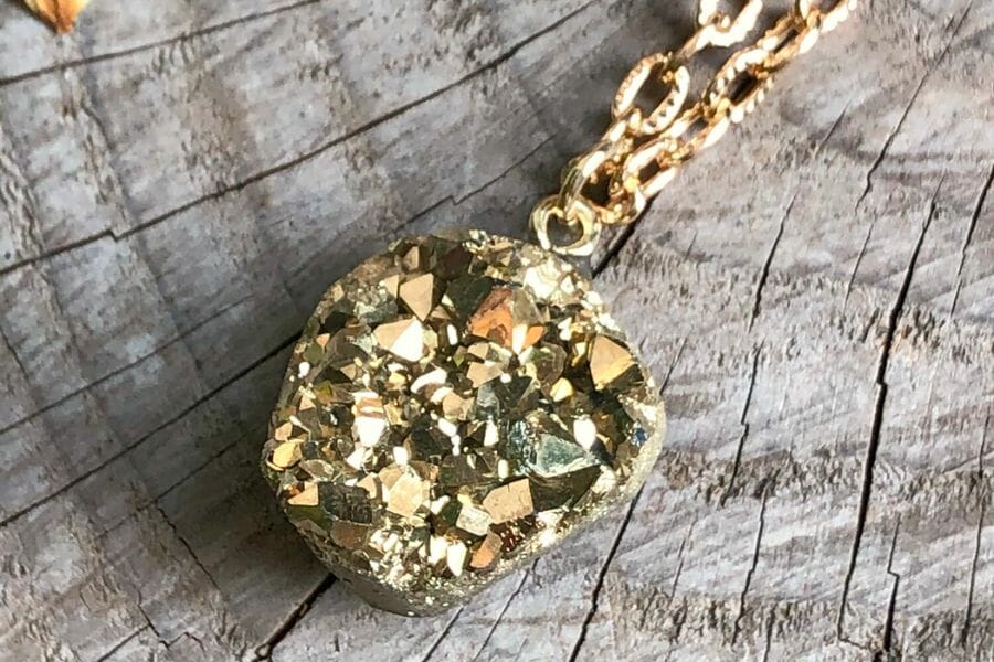 A pyrite specimen used as a pendant for a golden necklace