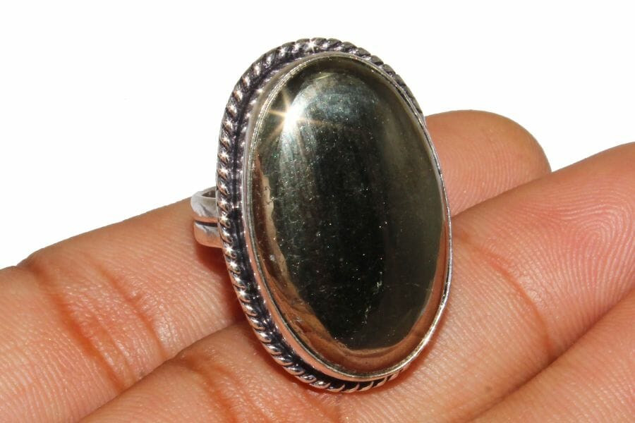 A shiny Pyrite Cabochon set as center stone of a silver ring