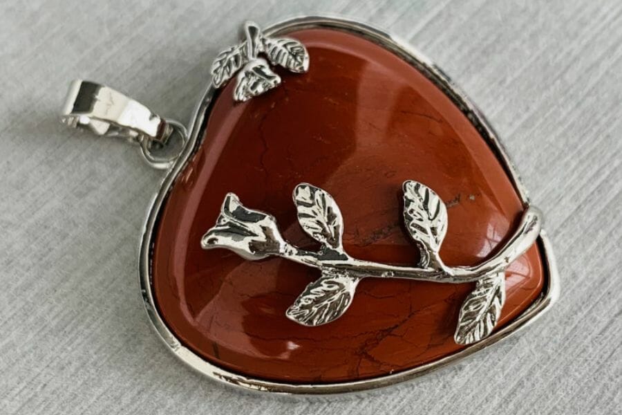 A heart-shaped red jasper pendant with a rose detail 