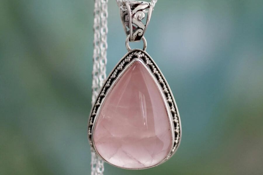 A gorgeous rose quartz necklace with intricate details around it