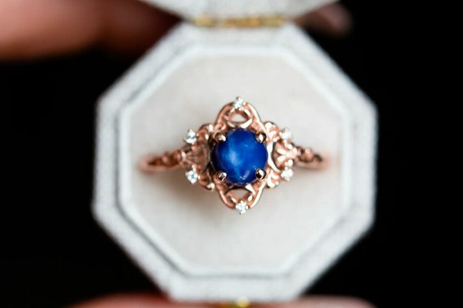 A top view of a golden ring encrusted with a round Star Sapphire