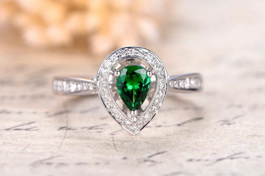 A stunning silver ring encrusted with small white diamonds and a green Tsavorite Garnet center stone