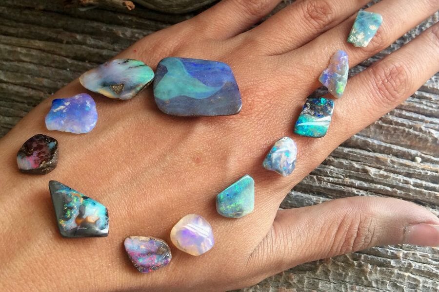 Various types of pretty opals beautifully arranged on a hand