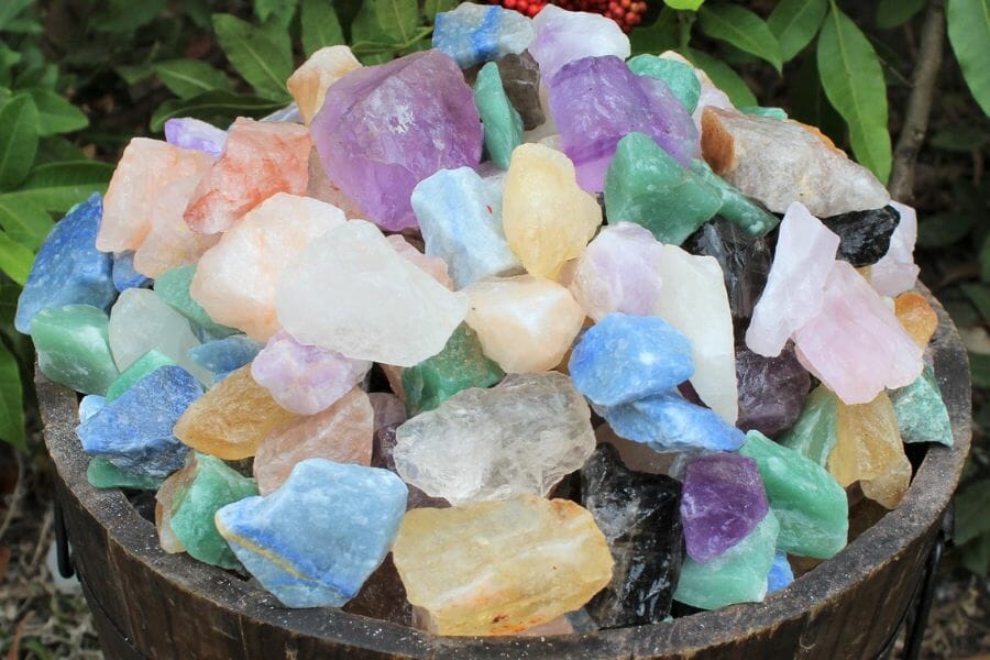 A bucket full of various colors of quartz crystals