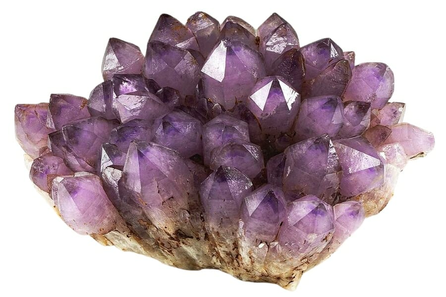 A cluster of sparkling, purple Amethyst crystals on a matrix