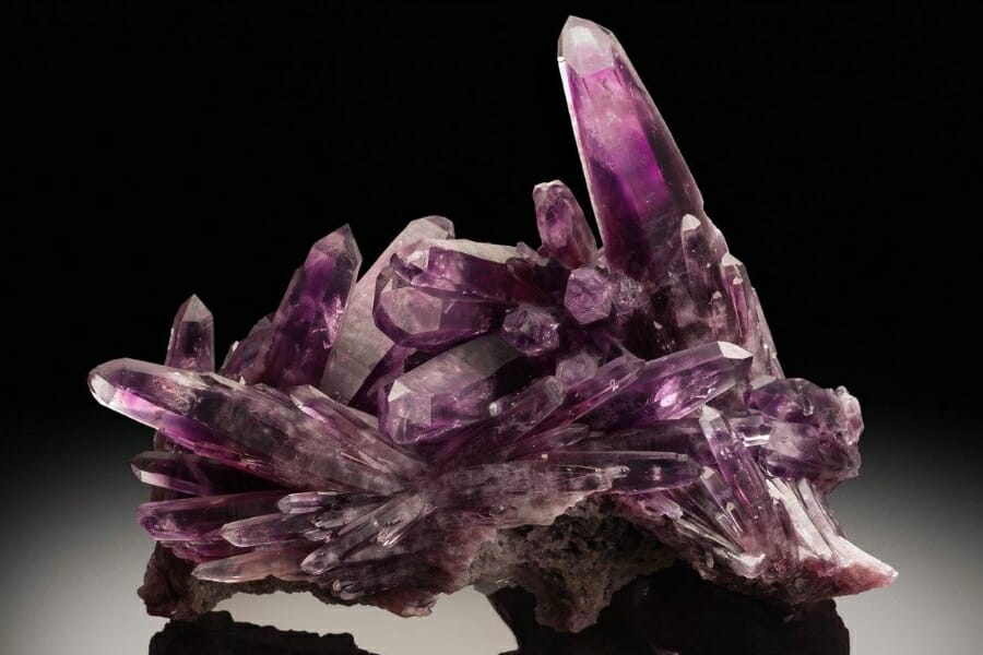 A cluster of stunning purple Amethyst crystals on black background