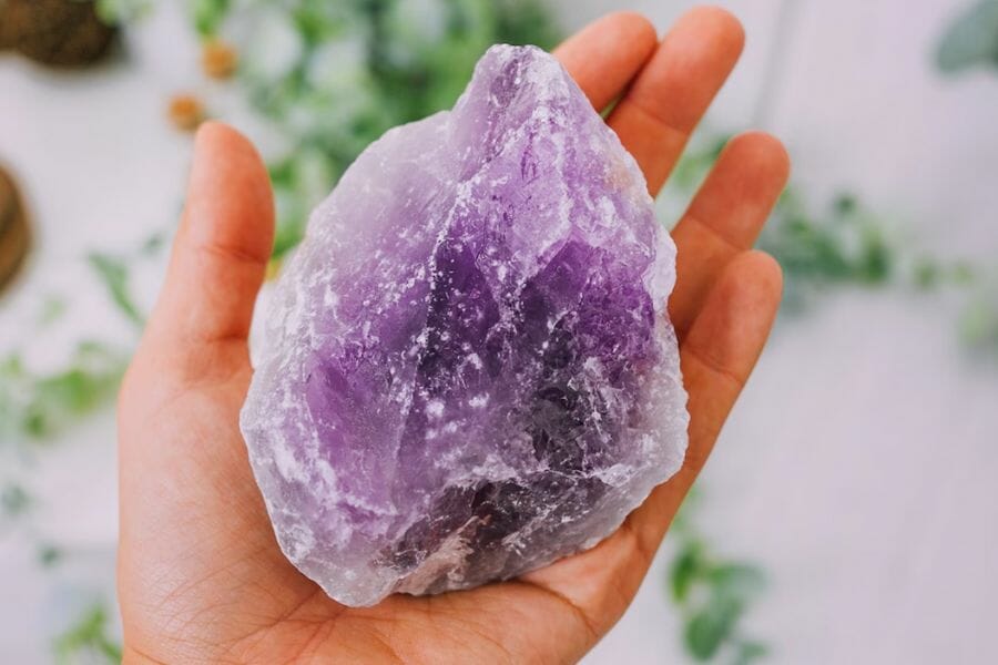 A dazzling amethyst crystal on a palm of a hand