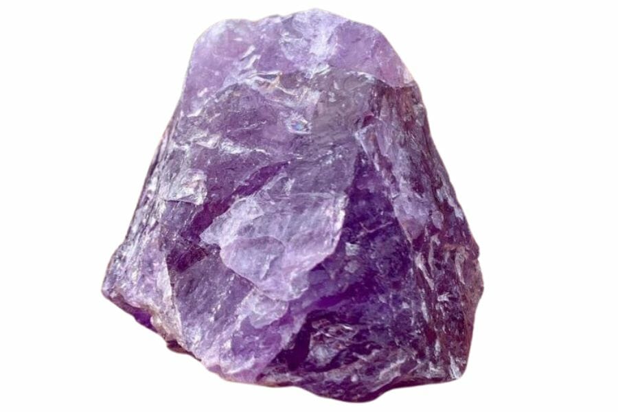 A pretty amethyst crystal placed on a light brown rough surface