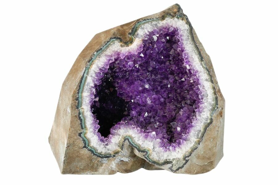 A huge amethyst geode cracked open with a thick rock lining