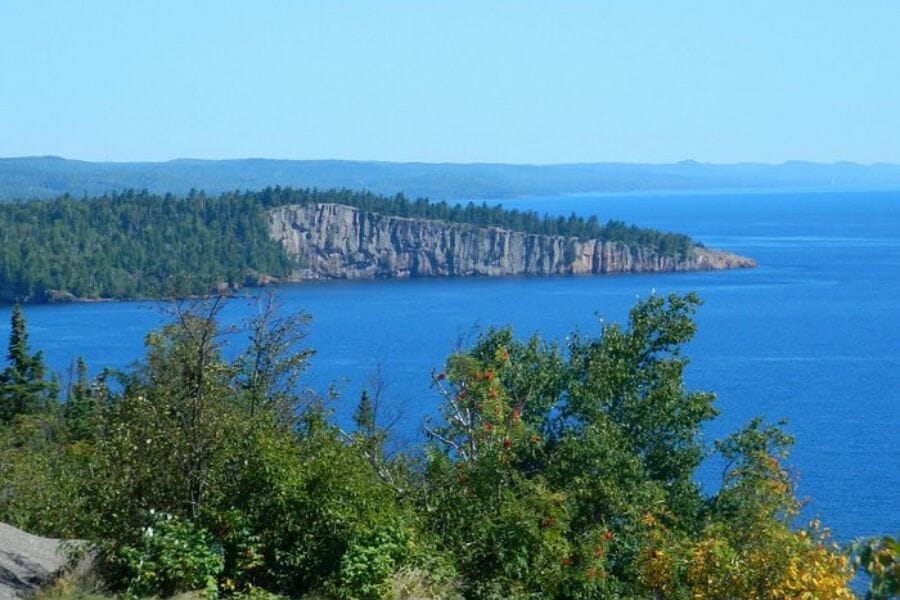 A nice picturesque view of Beaver Bay with blue waters and many trees on the mountain