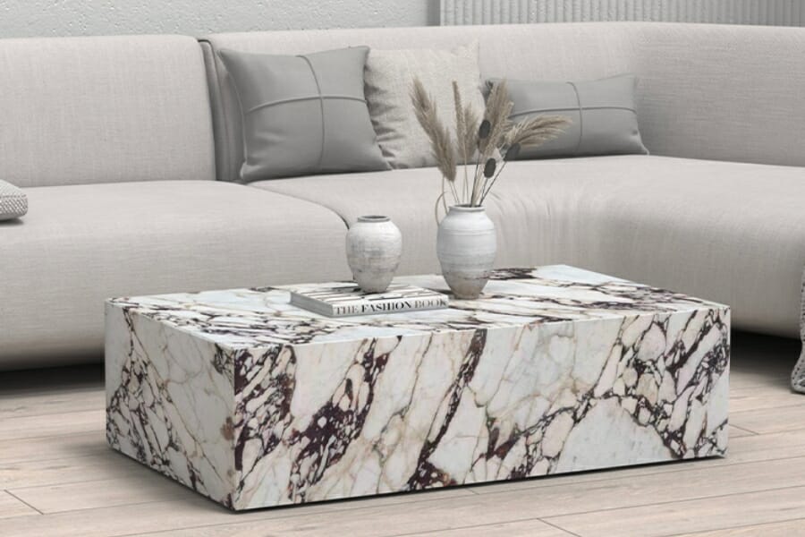 A thick slab of white Calacatta Viola with dark purple and cream veins used as a center table