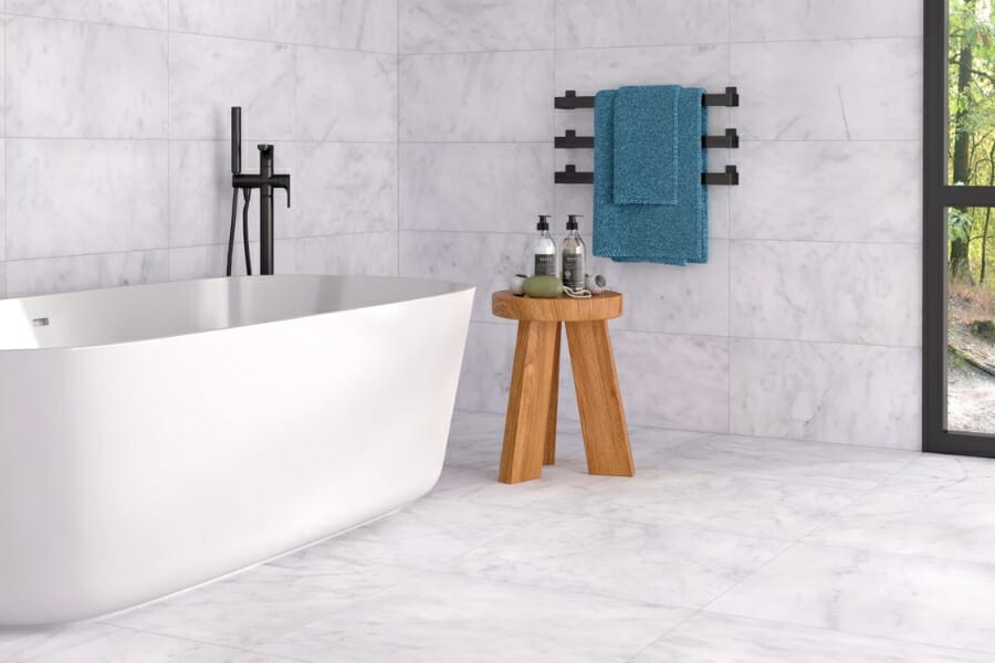 Grayish-white Carrara Marble tiles with darker gray veins used as bathroom flooring and walls