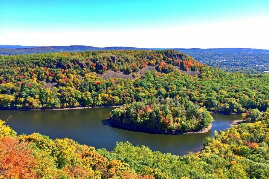 A scenic view from Hubbard Park of an island full of trees with mountains and hills in the background