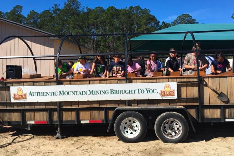 A group of kids busily sifting through dirt for gem and gold at the sluice of Huck's Lost Mine