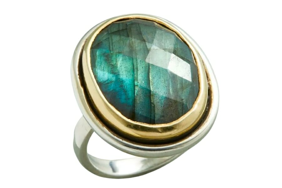 A close look at a faceted Labradorite set on a silver stone with gold edges