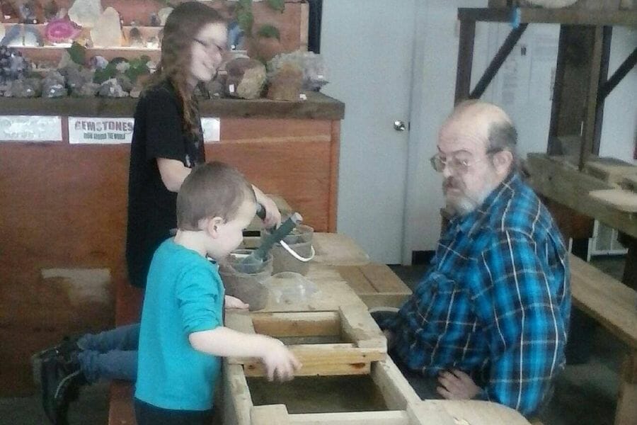 Two kids and a grandpa rockhounding for minerals and rocks at the Lucky 33 Gemstone Flume Mine