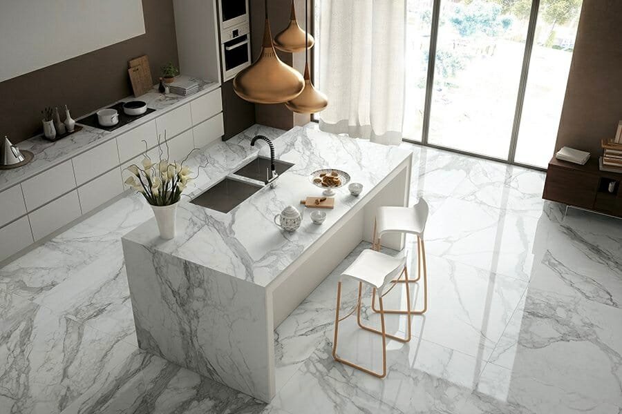 A top view of a kitchen countertop and flooring made out of white marble with gray veins