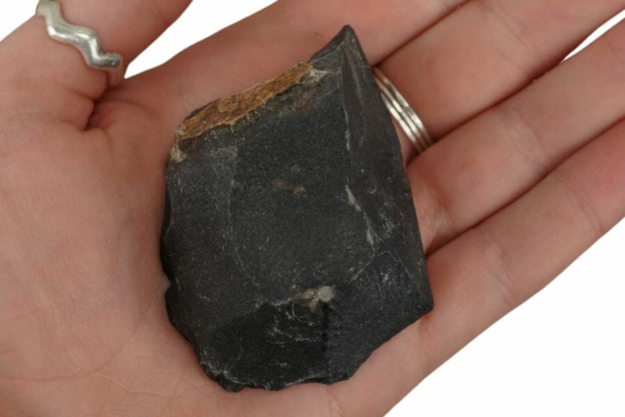 A pretty black onyx rock sitting on a hand