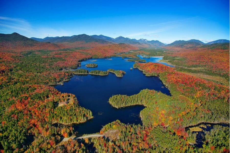 A pretty aerial view of the Opalescent River with lush trees and mountains in the background