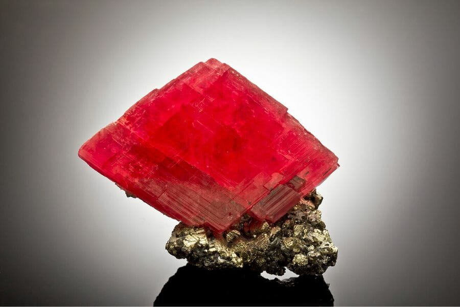 An elegant diamond-shaped rhodochrosite on chalcopyrite