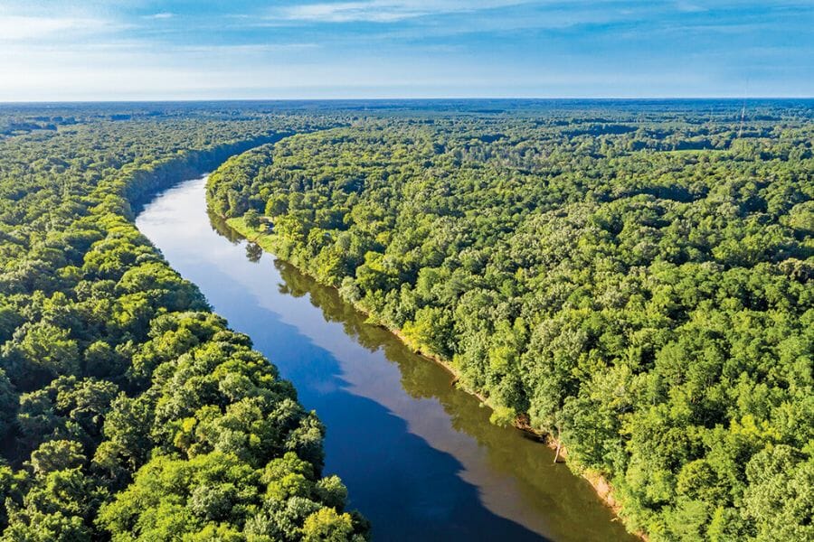 A scenic aerial view of the Ronoake River flowing between two lands filled with trees