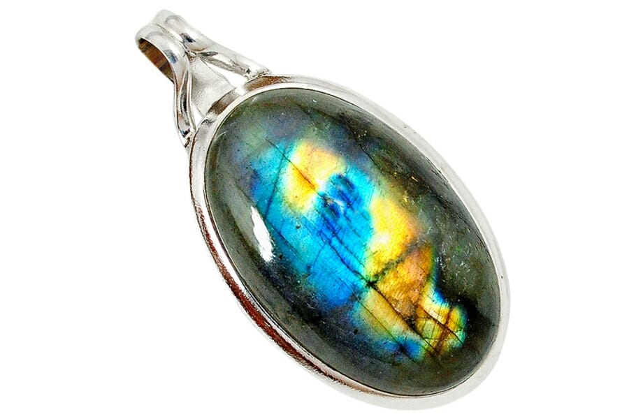A silver pendant with dark Spectrolite displaying blue and yellow Labradorescence as center stone