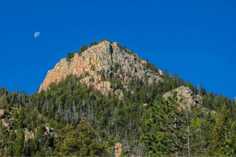 A photo of the peak of Stove Mountain beside a half moon