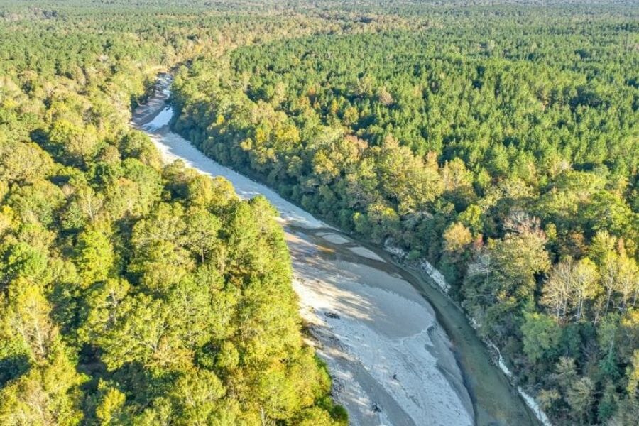 An aerial view of the Thompsoon Creek in between lands of trees where you can find minerals and rocks