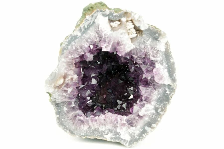 A unique amethyst crystal cluster inside a geode surrounded by white minerals