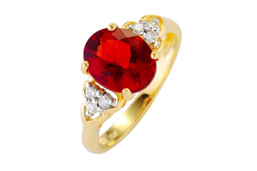 Beautiful golden ring with small white diamonds and a deep red Andesine as center stone