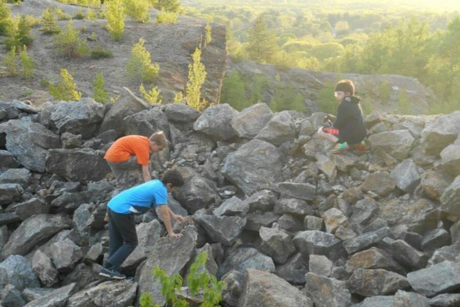 Kids climbing rocks in search for minerals at the Apple Valley Minerals