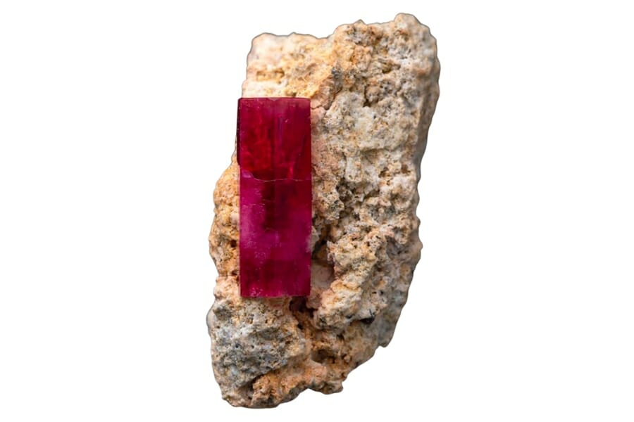 Vibrant red Beryl crystal attached to a rock