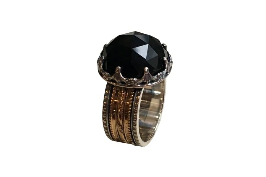 A silver gold spinner ring with a polished Black Carnelian as center stone