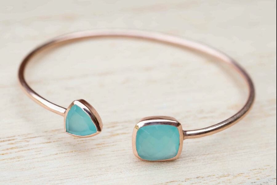 Two blue chalcedony gemstones on a rose gold bangle