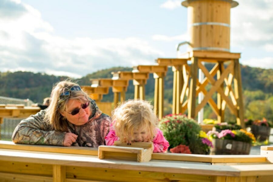 An adult and a little girl intensely looking at their sifted finds at the sluice of Brushcreek Falls RV Resort