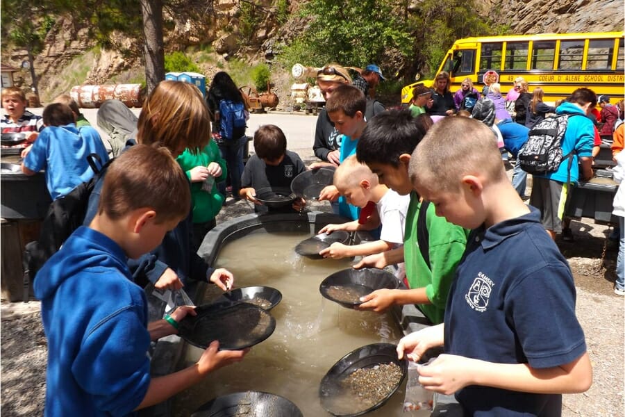 A group of children busily sifting for gems at the sluice of Crystal Gold Mine