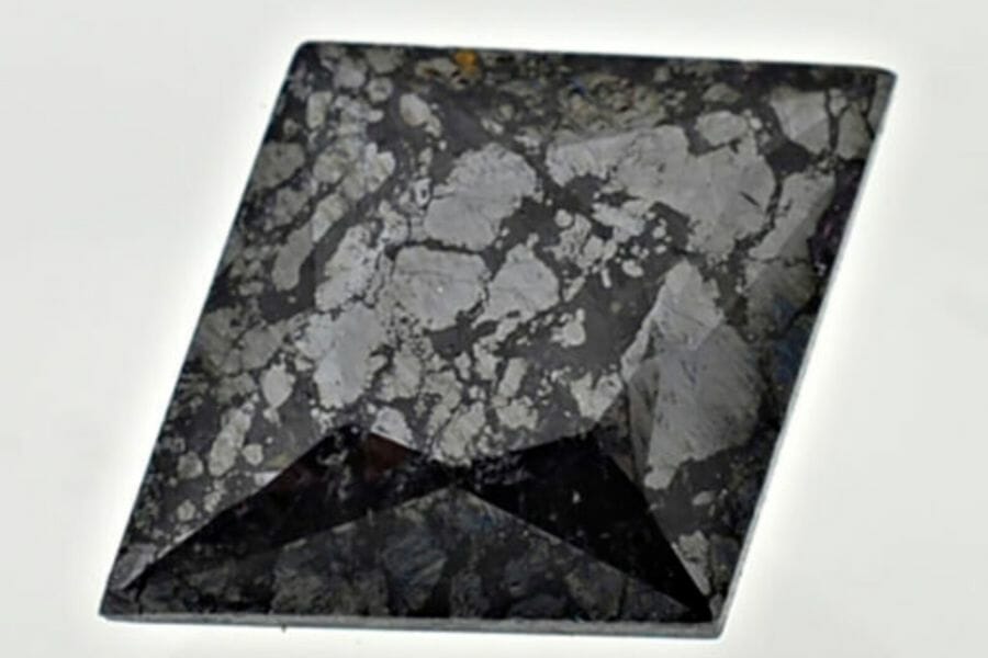 A diamond-cut shaped polished chromite with grayish spots