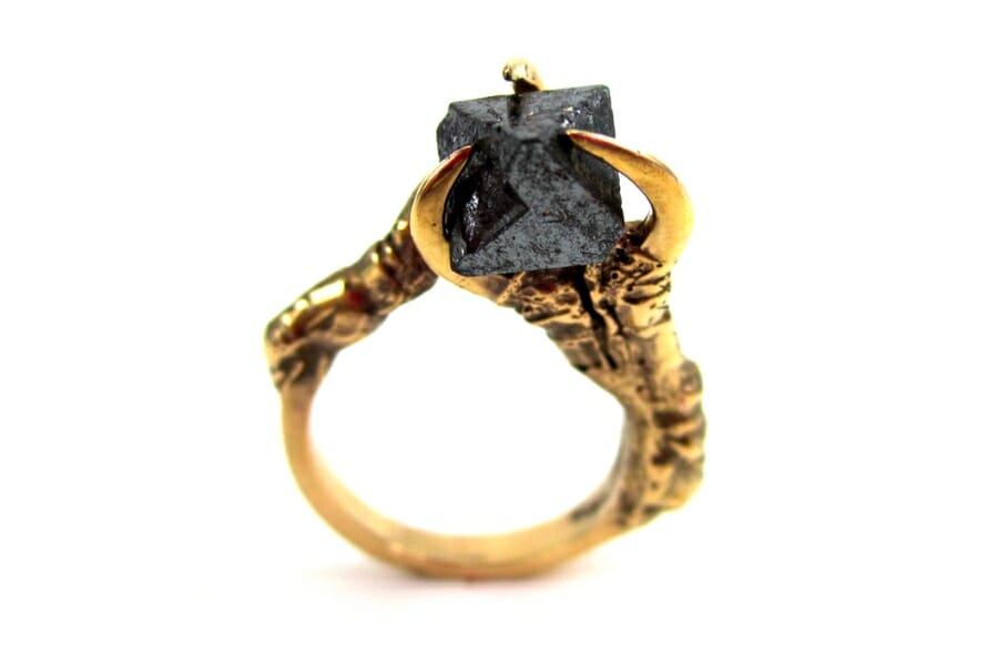 A gold ring with a faceted, black Magnetite as center stone