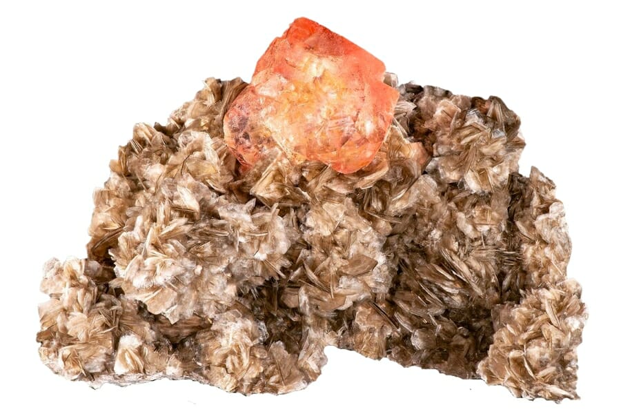 Pinkish peach Fluorite perched atop an intricate Muscovite