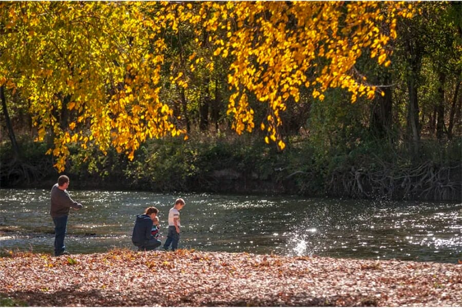 A family enjoying the view at a park with a creek and nearby trees at Galena